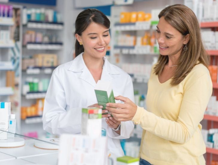 Pharmacist and customer looking at medicine